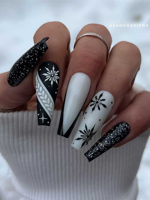 Las uñas de invierno de gel blanco y negro tienen forma de ataúd y cuentan con dos uñas negras con brillo brillante y un arte de uñas con forma de copo de nieve.