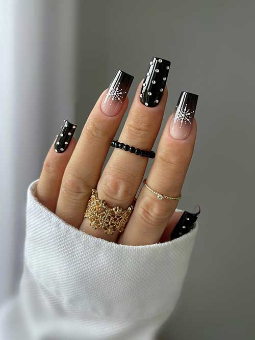 Uñas largas de invierno de color negro brillante, de forma cuadrada, con cristales y dos uñas decorativas en negro degradado con copos de nieve blancos.